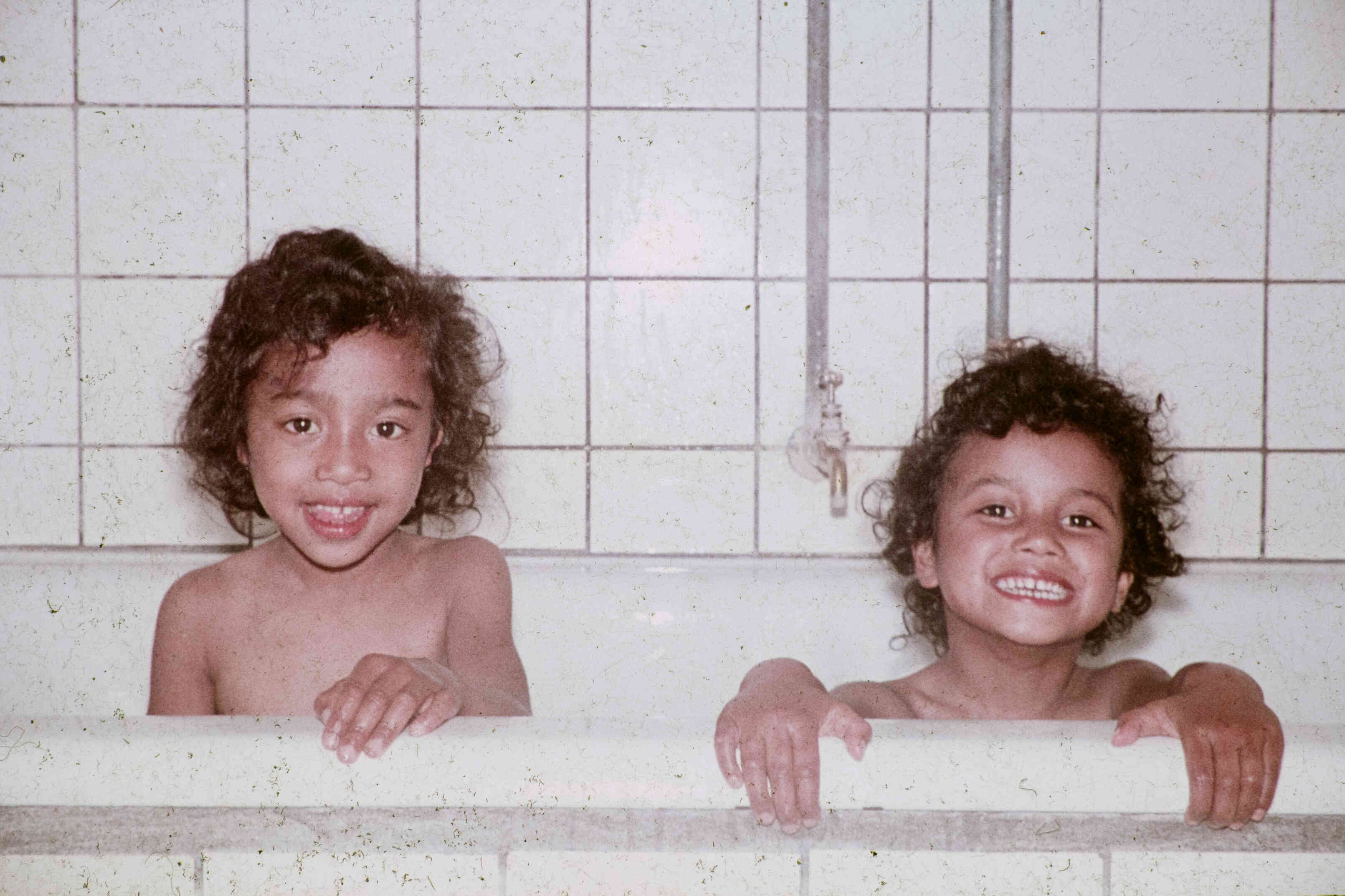 Oude foto van twee vrolijke kinderen in bad